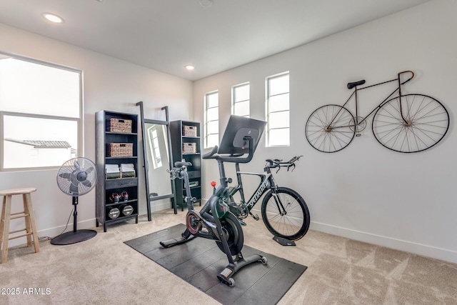 exercise area featuring recessed lighting, light colored carpet, and baseboards