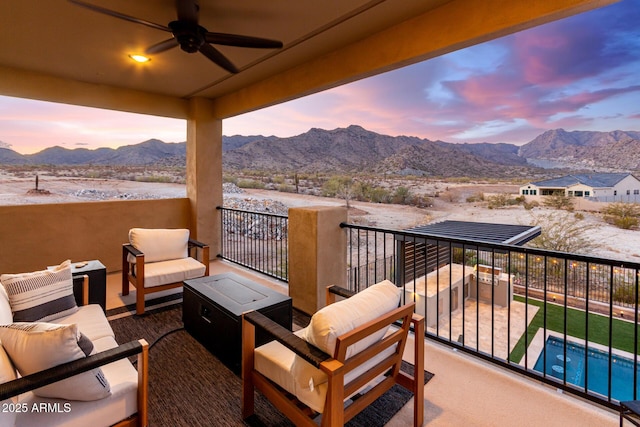 balcony with a mountain view, an outdoor hangout area, and a ceiling fan