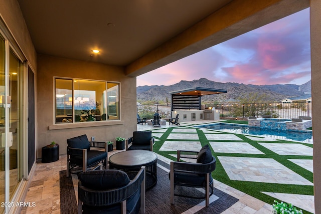 view of patio / terrace with a pool with connected hot tub, a fenced backyard, and a mountain view