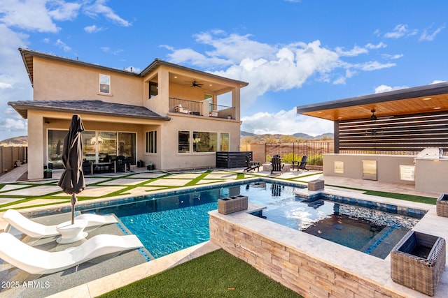 view of swimming pool with fence, a mountain view, a ceiling fan, and a patio