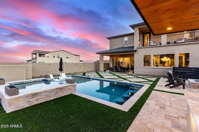 pool at dusk featuring a fenced in pool, a fenced backyard, a patio, and an in ground hot tub