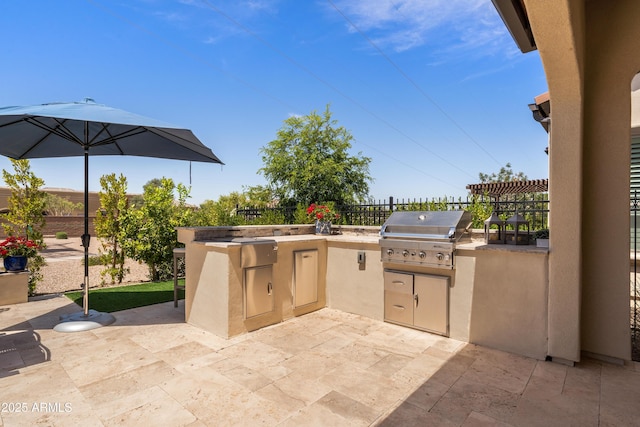 view of patio / terrace featuring an outdoor kitchen, fence, and a grill