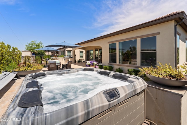 view of patio / terrace featuring a hot tub and outdoor dining space