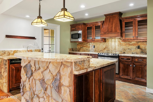 kitchen featuring a center island, premium range hood, pendant lighting, decorative backsplash, and appliances with stainless steel finishes