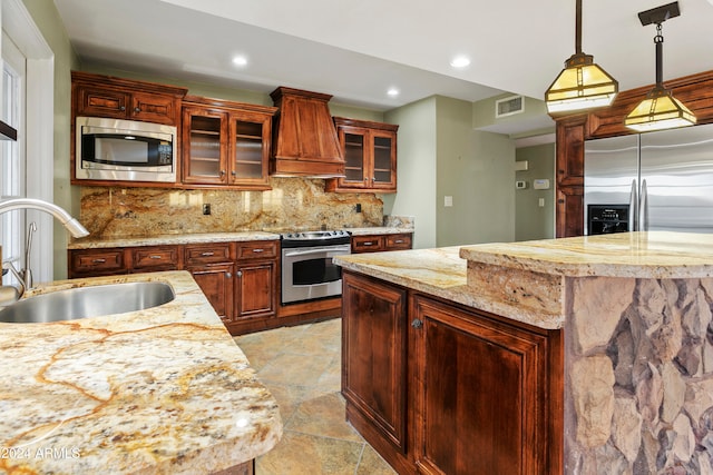 kitchen with decorative backsplash, custom range hood, stainless steel appliances, sink, and pendant lighting