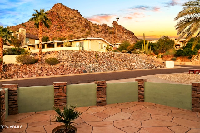 patio terrace at dusk featuring a mountain view