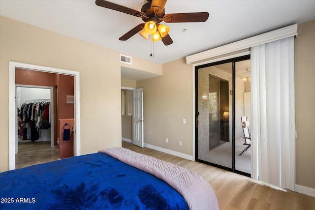15151 N Frank Lloyd Wright Blvd Unit 2086, Scottsdale, AZ 85260 - bedroom featuring access to exterior, wood finished floors, a closet, ceiling fan, and a walk in closet