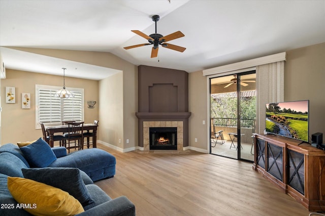 15151 N Frank Lloyd Wright Blvd Unit 2086, Scottsdale, AZ 85260 - living room with ceiling fan, light wood-type flooring, vaulted ceiling, and a tile fireplace