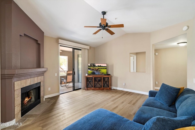 15151 N Frank Lloyd Wright Blvd Unit 2086, Scottsdale, AZ 85260 - living room with lofted ceiling, wood finished floors, a ceiling fan, and a tiled fireplace