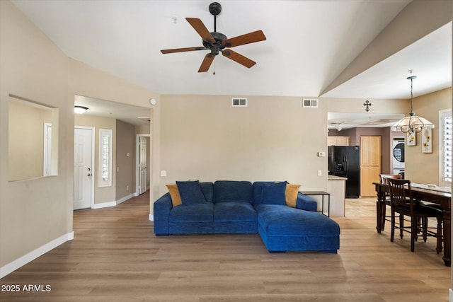 15151 N Frank Lloyd Wright Blvd Unit 2086, Scottsdale, AZ 85260 - living area featuring a ceiling fan, light wood finished floors, vaulted ceiling, and stacked washer / dryer