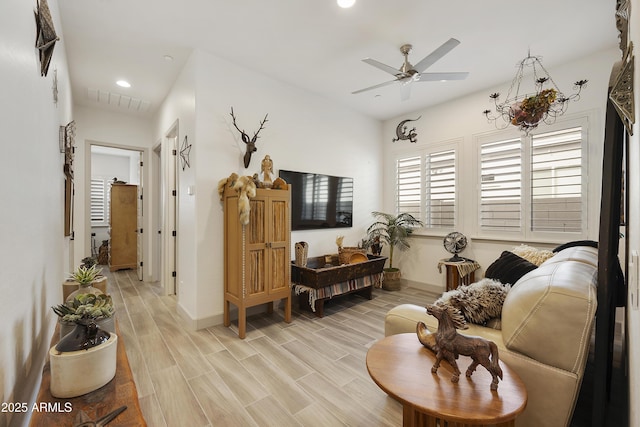 living room with ceiling fan and light wood-type flooring