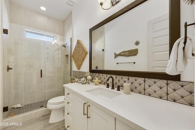 bathroom with backsplash, vanity, toilet, and walk in shower