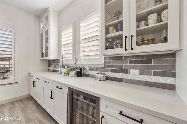 bar featuring white cabinets, wine cooler, and tasteful backsplash