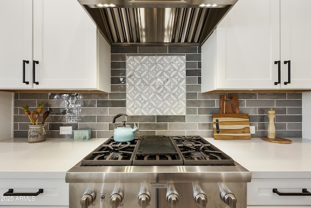 kitchen featuring tasteful backsplash, white cabinetry, stainless steel gas cooktop, and custom exhaust hood