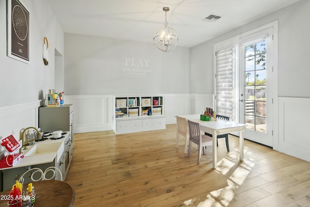 game room featuring wainscoting, a notable chandelier, visible vents, and light wood finished floors