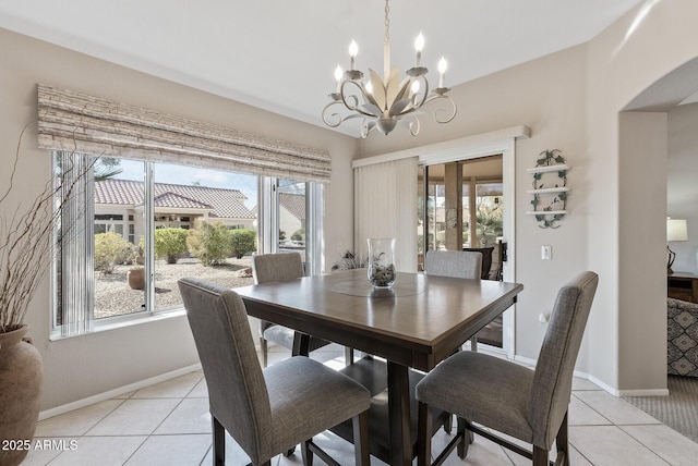 dining area featuring light tile patterned flooring, a wealth of natural light, and a notable chandelier