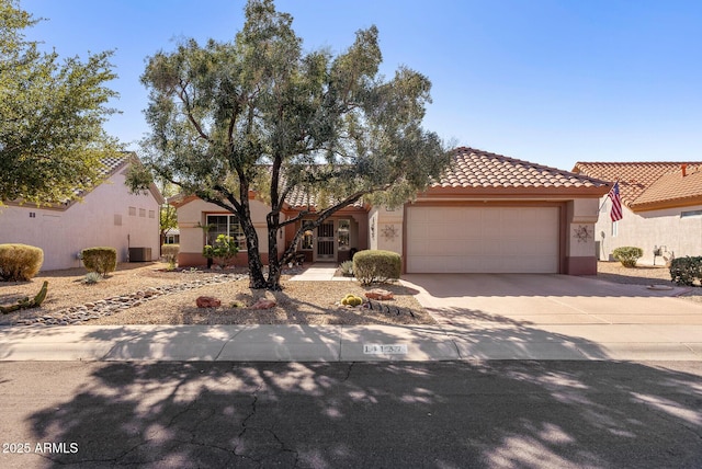 mediterranean / spanish-style home featuring a garage and central AC unit