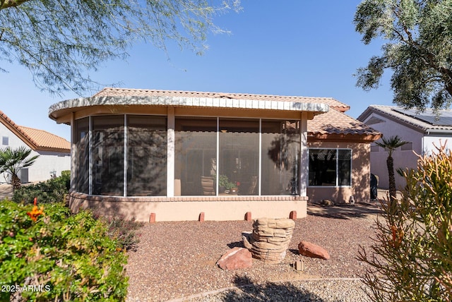 rear view of house featuring a sunroom