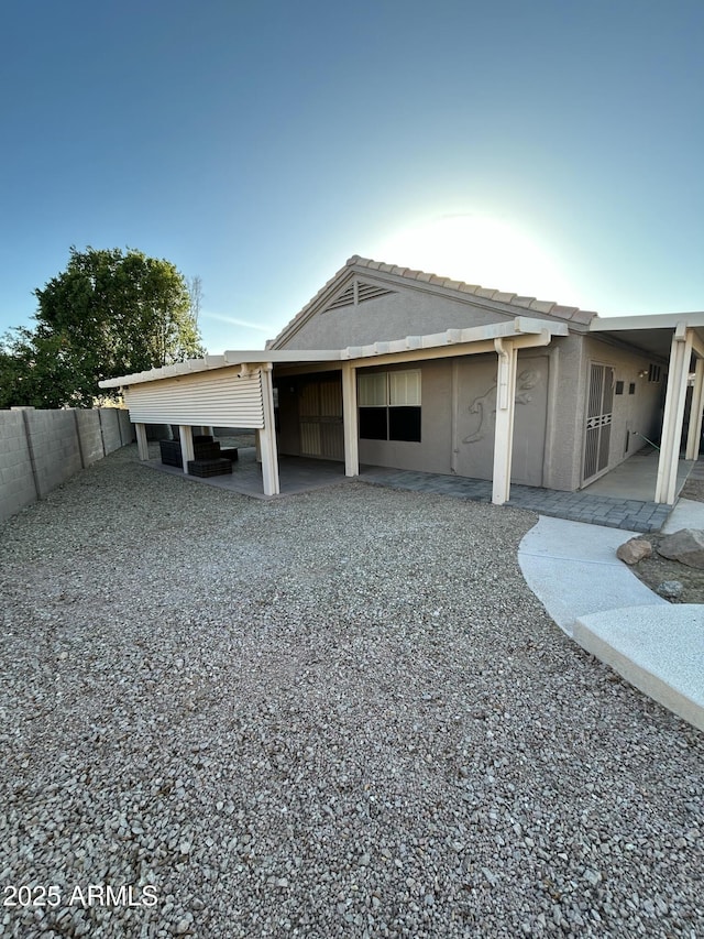 back of house with stucco siding, fence, and a patio area