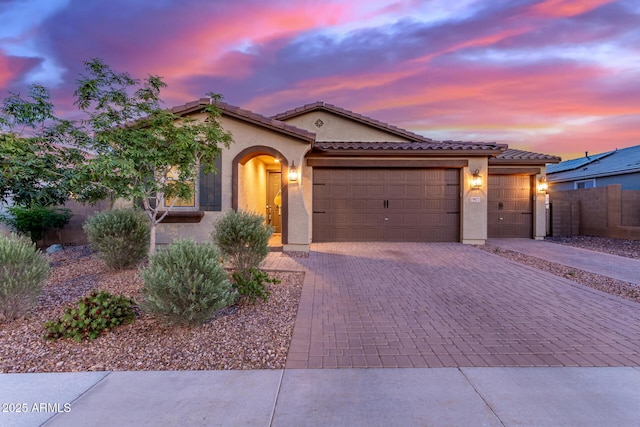19873 W San Juan Ave, Litchfield Park, AZ 85340 - mediterranean / spanish-style home with decorative driveway, a garage, stucco siding, and a tiled roof
