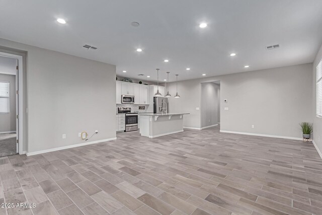 19873 W San Juan Ave, Litchfield Park, AZ 85340 - unfurnished living room with recessed lighting, baseboards, and light wood finished floors