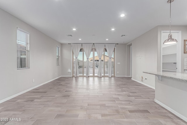 19873 W San Juan Ave, Litchfield Park, AZ 85340 - unfurnished living room featuring recessed lighting, baseboards, and light wood-style floors