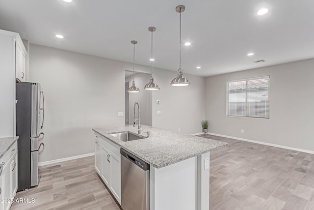 19873 W San Juan Ave, Litchfield Park, AZ 85340 - kitchen with stainless steel appliances, a sink, white cabinetry, baseboards, and a kitchen island with sink