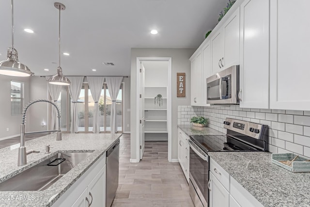 19873 W San Juan Ave, Litchfield Park, AZ 85340 - kitchen with appliances with stainless steel finishes, a sink, decorative backsplash, recessed lighting, and white cabinets