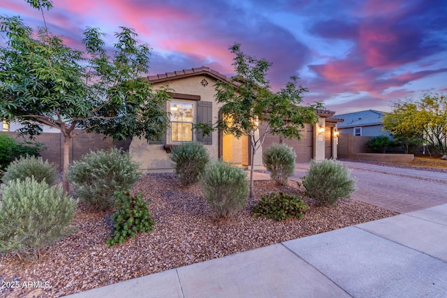 19873 W San Juan Ave, Litchfield Park, AZ 85340 - mediterranean / spanish-style home featuring a garage, decorative driveway, stucco siding, a tiled roof, and fence
