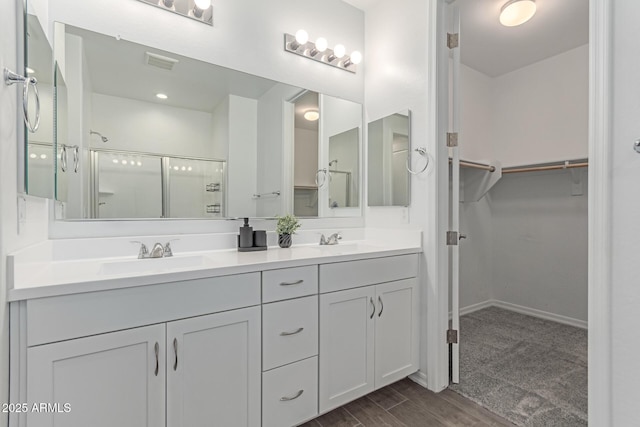 19873 W San Juan Ave, Litchfield Park, AZ 85340 - full bath featuring a shower stall, double vanity, a spacious closet, wood finished floors, and baseboards