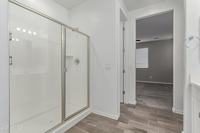 19873 W San Juan Ave, Litchfield Park, AZ 85340 - full bathroom with a stall shower, vanity, baseboards, and wood finished floors