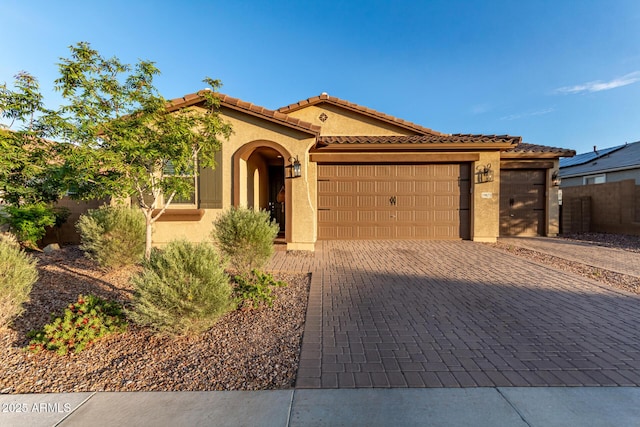 19873 W San Juan Ave, Litchfield Park, AZ 85340 - mediterranean / spanish-style house with an attached garage, stucco siding, decorative driveway, and a tiled roof