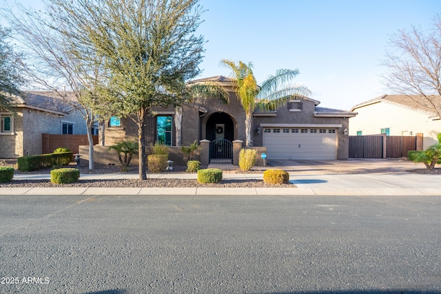 view of front of house featuring a fenced front yard, a garage, concrete driveway, a gate, and stucco siding