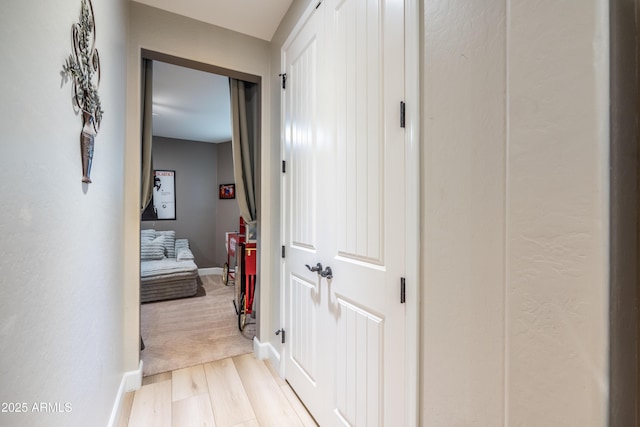 hall featuring wood finished floors and baseboards