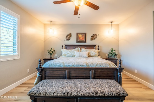 bedroom featuring light wood finished floors, ceiling fan, and baseboards