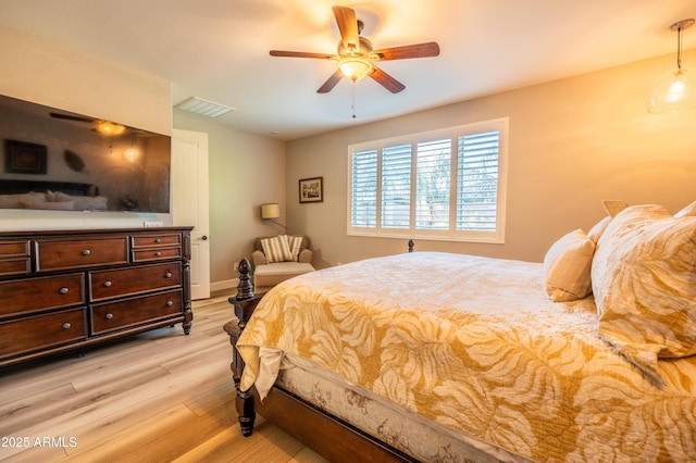 bedroom with baseboards, visible vents, ceiling fan, and light wood finished floors