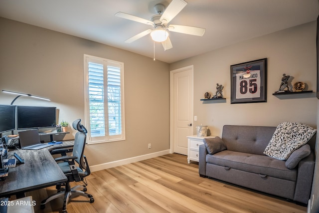 home office with light wood-style floors, ceiling fan, and baseboards