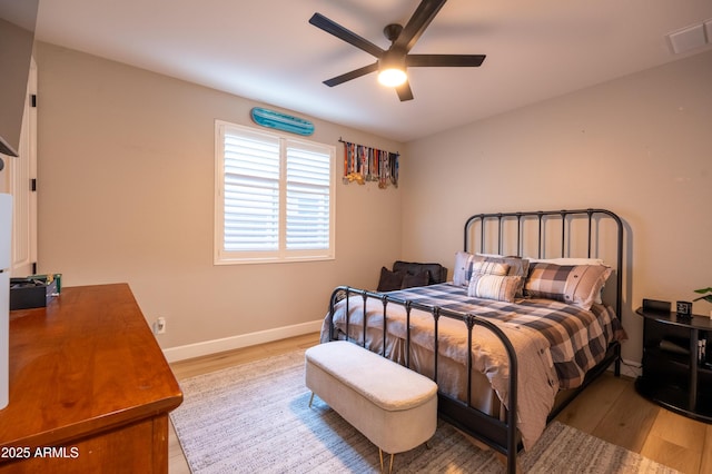 bedroom with light wood-type flooring, baseboards, visible vents, and a ceiling fan