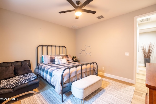 bedroom with ceiling fan, light wood-type flooring, visible vents, and baseboards