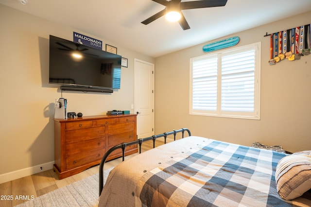 bedroom with ceiling fan, wood finished floors, and baseboards