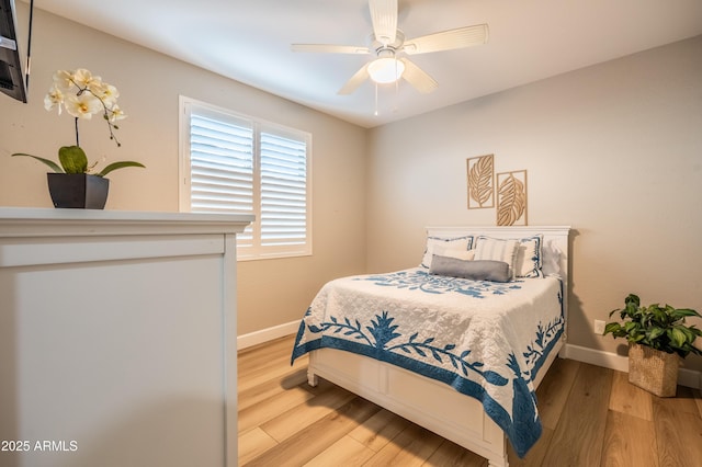 bedroom featuring a ceiling fan, baseboards, and wood finished floors