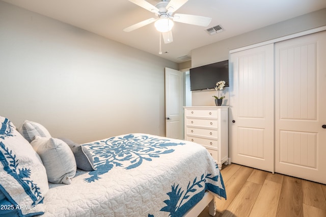 bedroom with a ceiling fan, light wood-style flooring, visible vents, and a closet