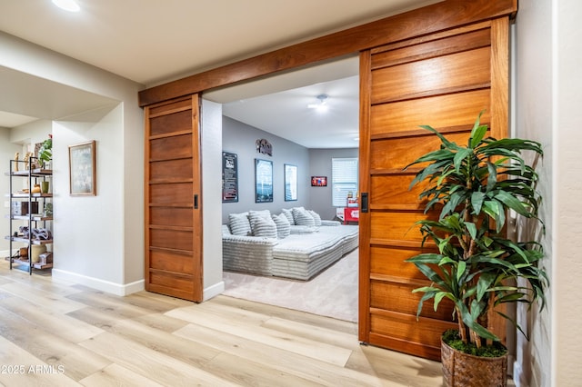 hall with light wood-type flooring and baseboards