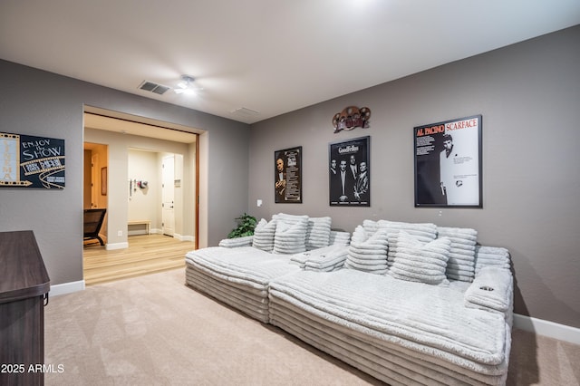 living room with light colored carpet, visible vents, and baseboards