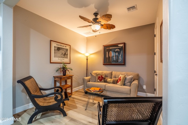 living area featuring light wood-style floors, visible vents, ceiling fan, and baseboards