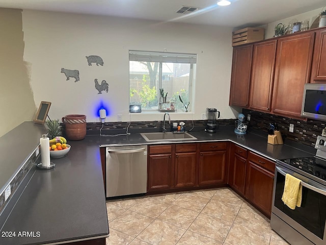 kitchen featuring appliances with stainless steel finishes, light tile patterned floors, sink, and decorative backsplash