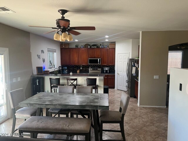 dining room featuring light tile patterned flooring, sink, and ceiling fan