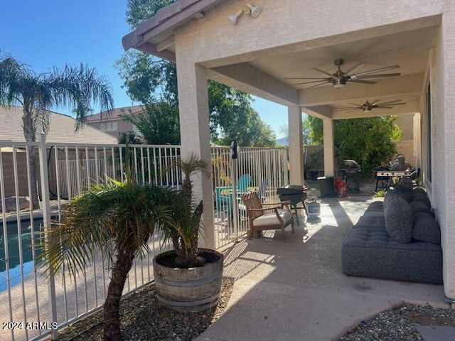 view of patio featuring ceiling fan and a fenced in pool