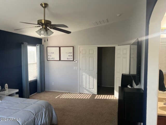 carpeted bedroom with ceiling fan and vaulted ceiling