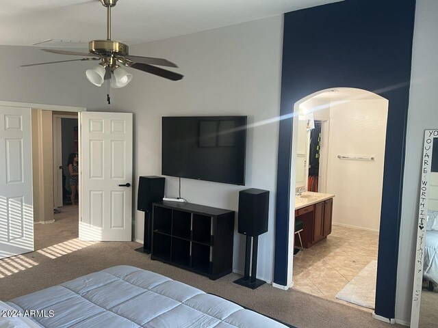 bedroom featuring ensuite bath, light carpet, high vaulted ceiling, and ceiling fan